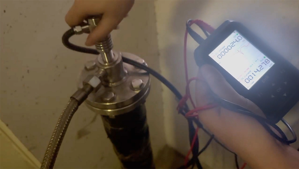 Technician calibrating a capacitive level sensor using diagnostic equipment during installation or maintenance.