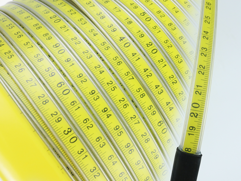 Close-up of yellow graduated steel ruler tape showing clear measurement markings
